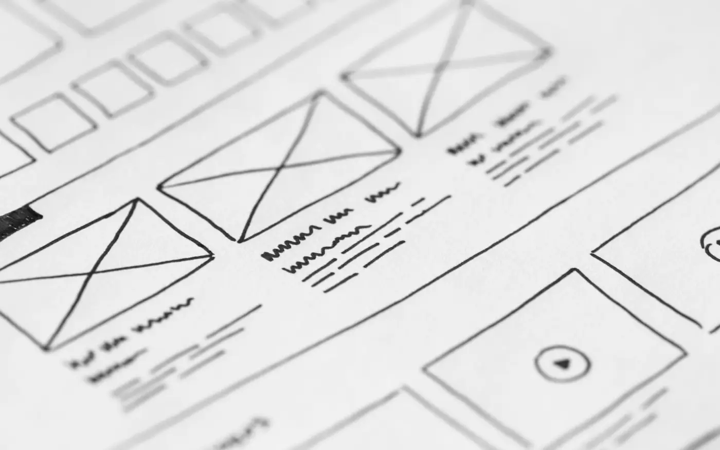 A hand-drawn website wireframe on paper, boxes marking where pages and images go